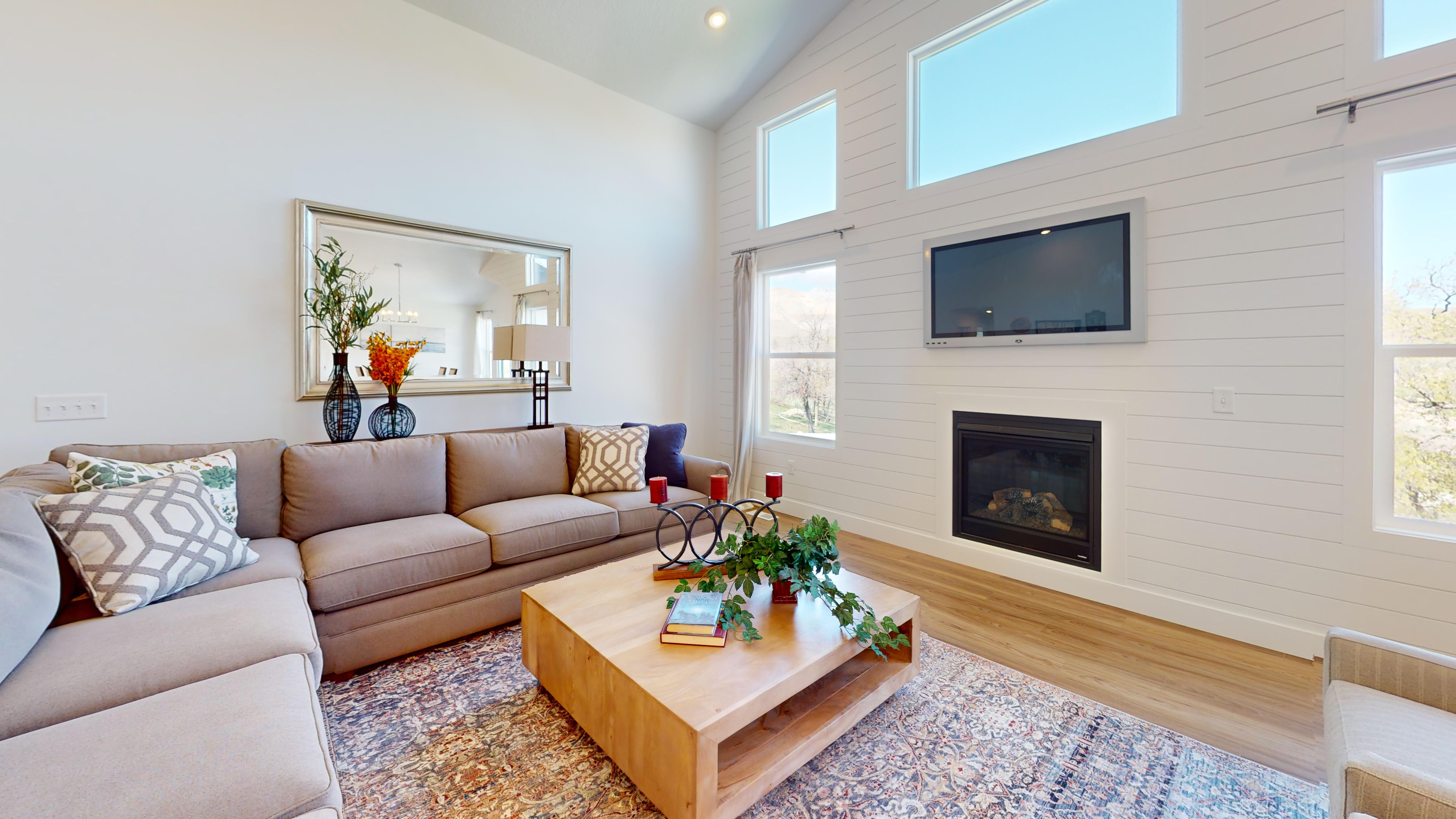 Denali model living room with fireplace and high windows